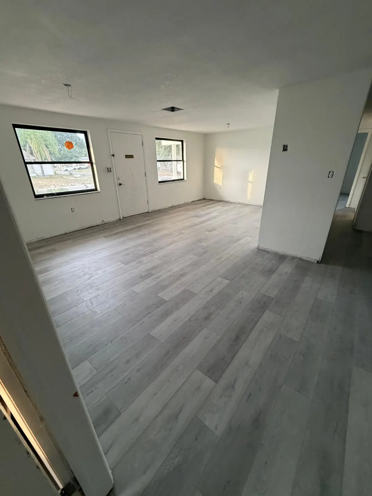 Gray wood-look plank flooring in an empty room with white walls