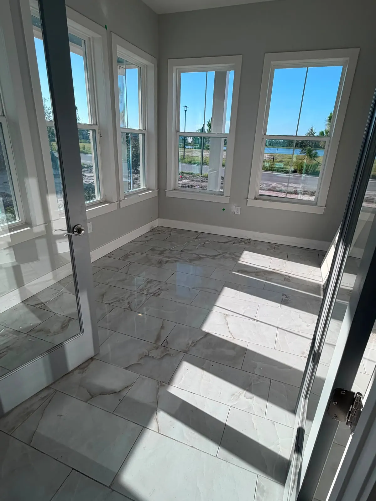 Marble-look tile floor in a bright room with large windows