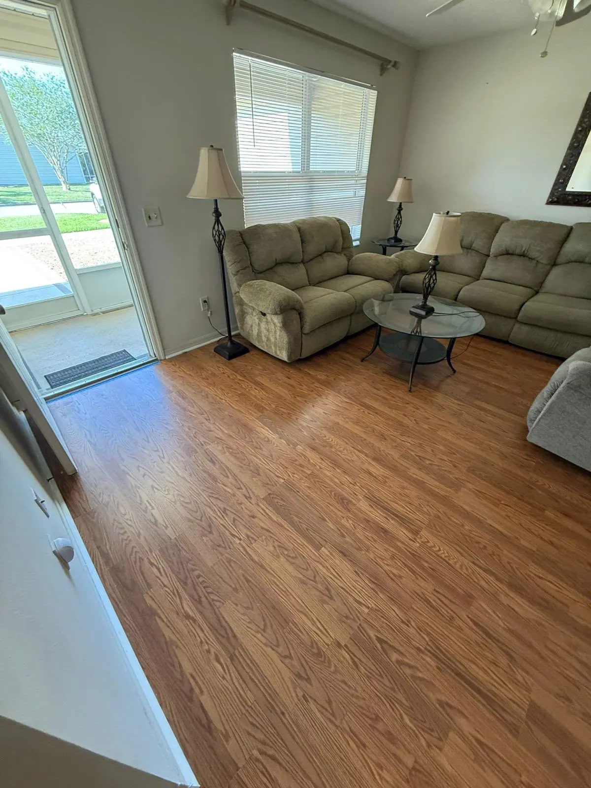 Wood-look plank flooring in a furnished living room with a sliding glass door
