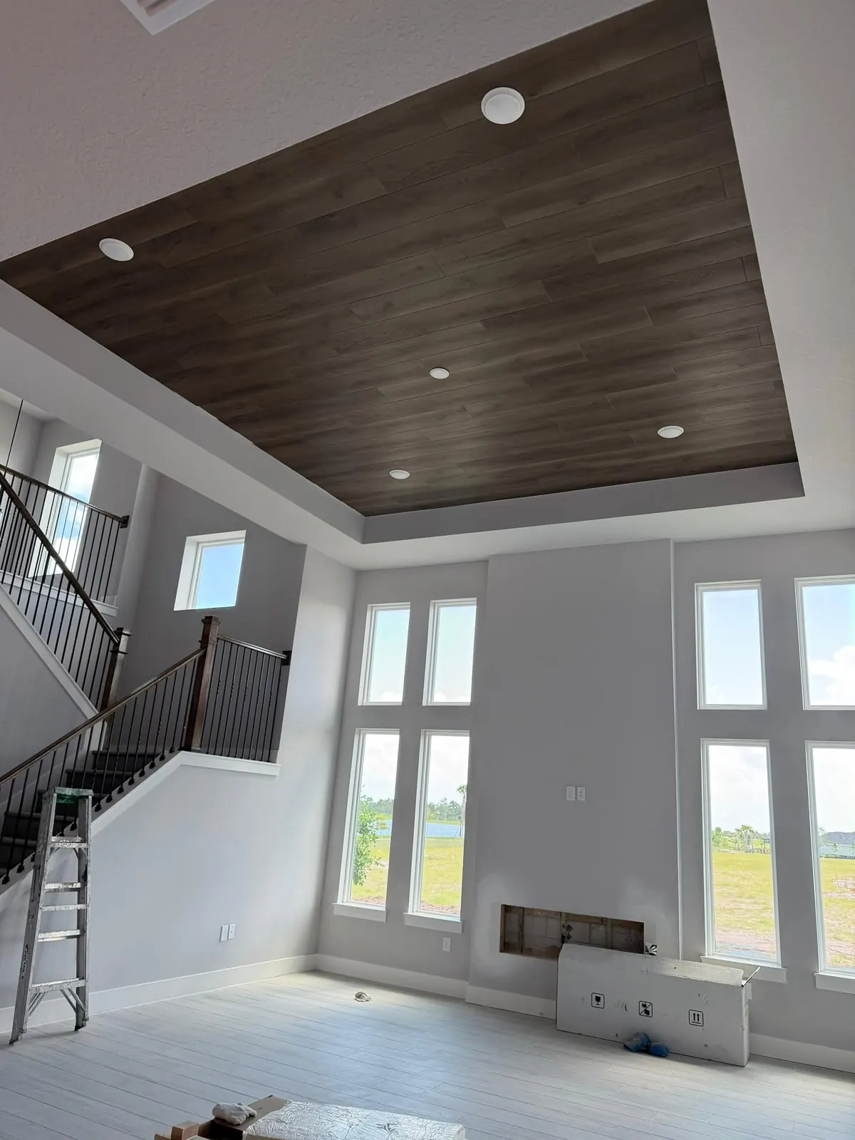 Wood-look planks installed on a tray ceiling in a two-story room