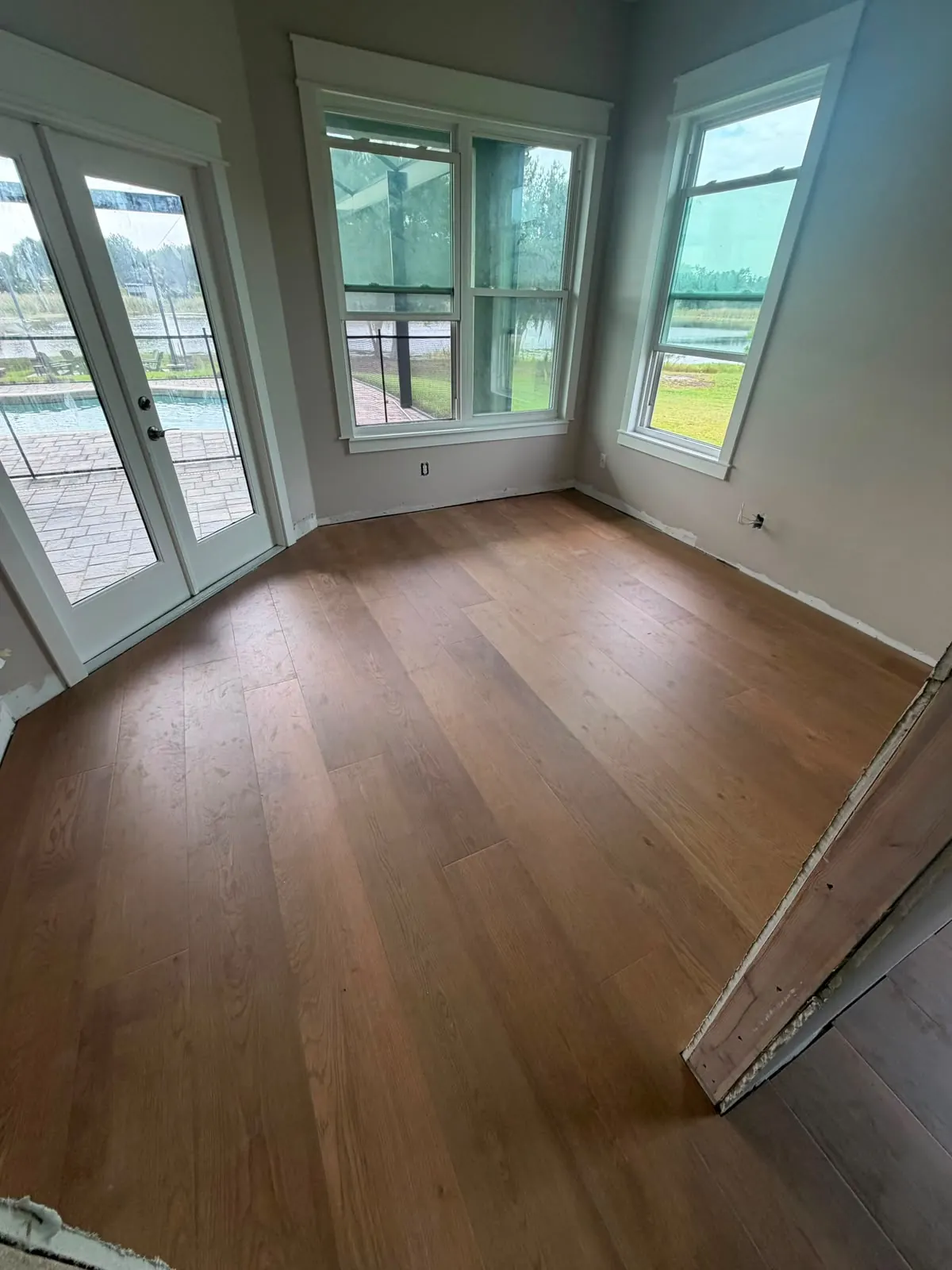 Medium brown wood-look vinyl plank floor in a bright room with French doors